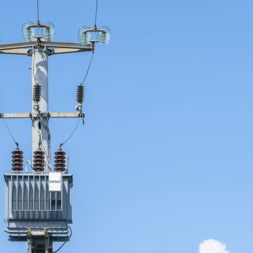 Electrical transformer of electrical pylon against the blue sky